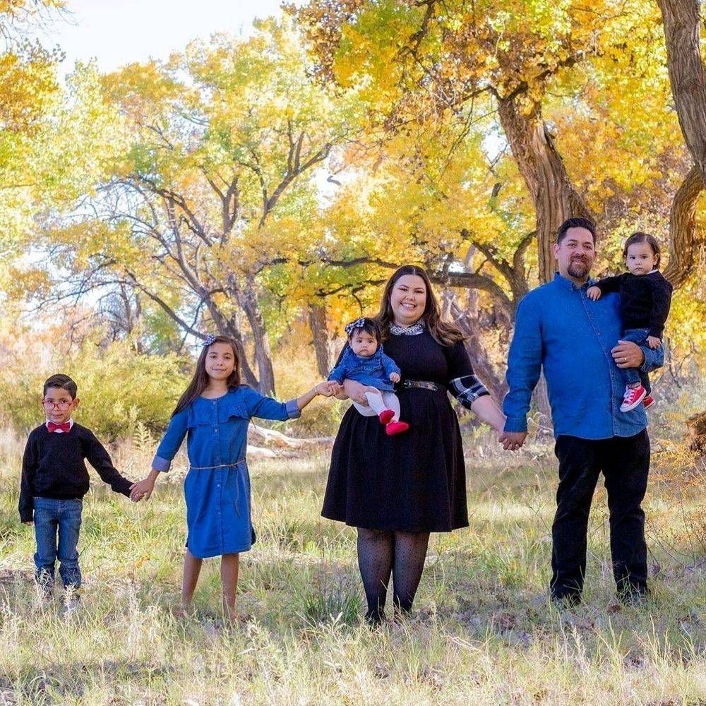 A family holding hands under yellow fall cottonwood trees
